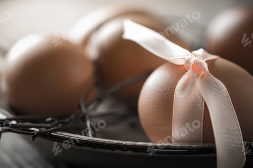 Preview: Eggs with ribbon and branches on the old plate close-up