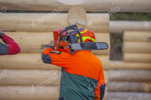 Preview: Worker holding a chainsaw in construction area
