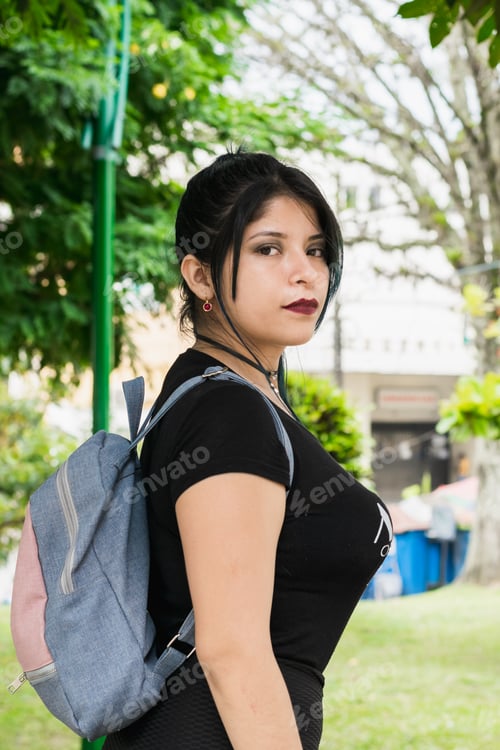 Preview: Latin college girl with blue hair walking through the park dressed in black and blue bag