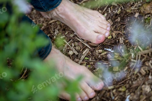 Preview: Bare foot next to a smoldering fire in nature.