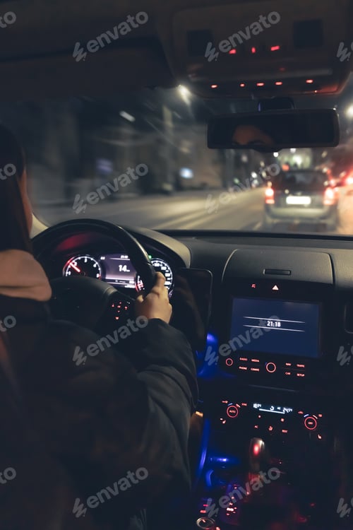 Preview: Driving a car at night, a woman driving her modern car at night in the city.