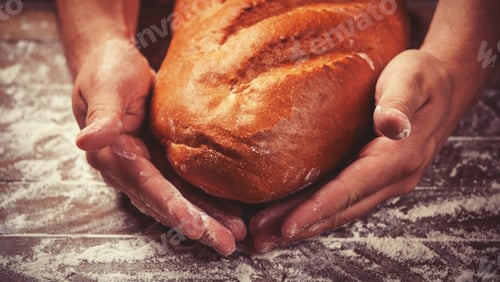 Preview: Baker's hands with a bread. Photo with high contrast