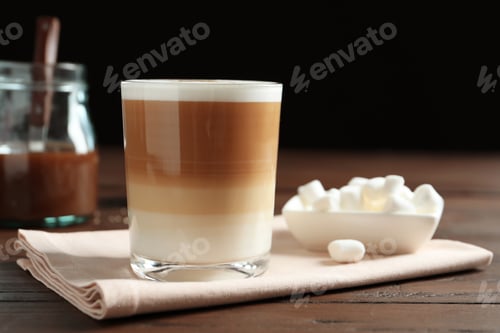 Preview: Glass with delicious caramel latte on table