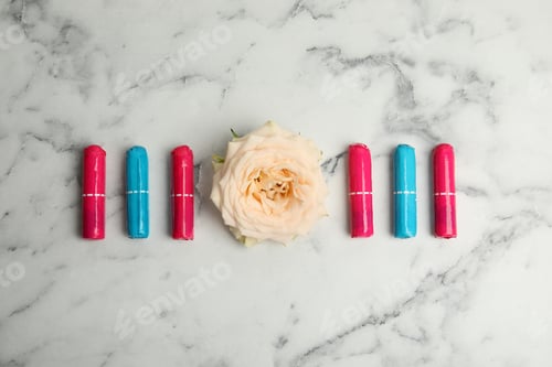 Preview: Colorful tampons and rose on white marble background, flat lay