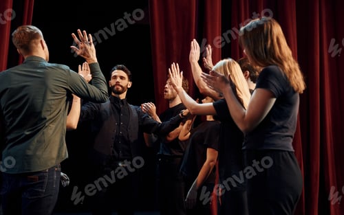 Preview: Group of actors in dark colored clothes on rehearsal in the theater