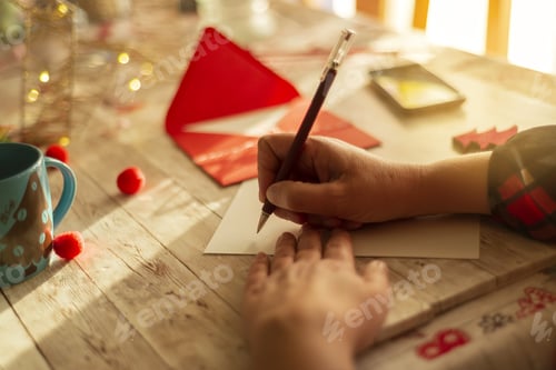 Preview: Person writing Christmas letter greeting card holiday wishes.