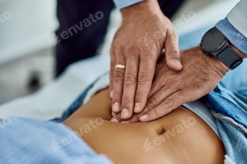 Preview: Medical Professional Examining Patient's Abdomen During Check-Up Appointment