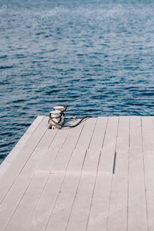 Preview: empty wooden pier and blue water at summer day