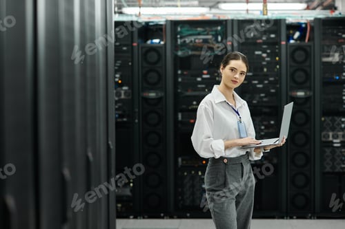 Preview: An IT specialist in a white shirt works hard in a modern server room managing systems.