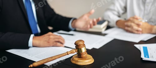 Preview: Two men are sitting at a table with a gavel on it