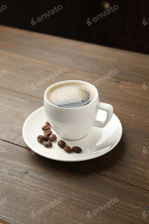 Preview: Aromatic coffee in cup and beans on wooden table