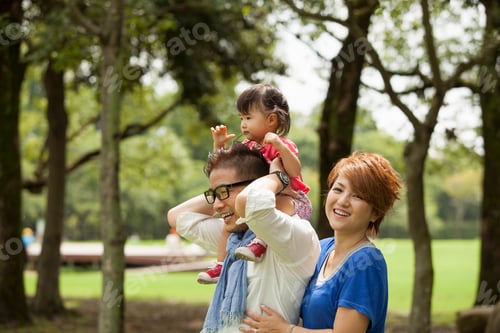 Preview: Family in a park. Two parents and a toddler.