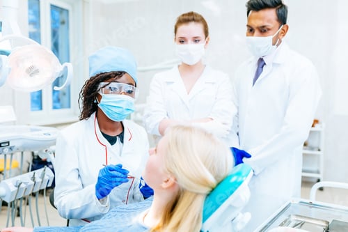 Preview: Multiracial dental team with patient in dental clinic. Dental health concept