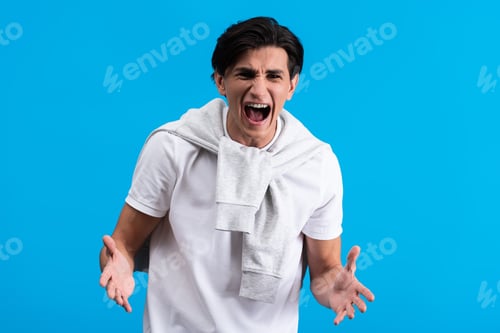 Preview: aggressive young man shouting isolated on blue