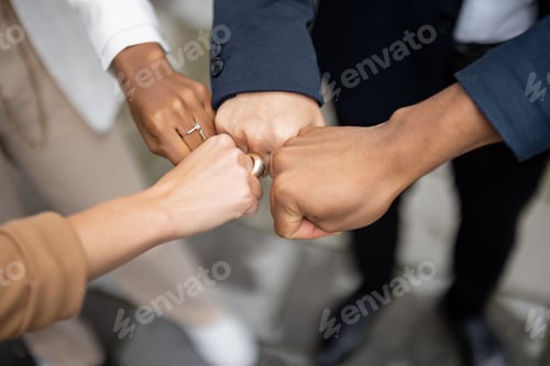 Preview: Cropped image of team bumping fists each other