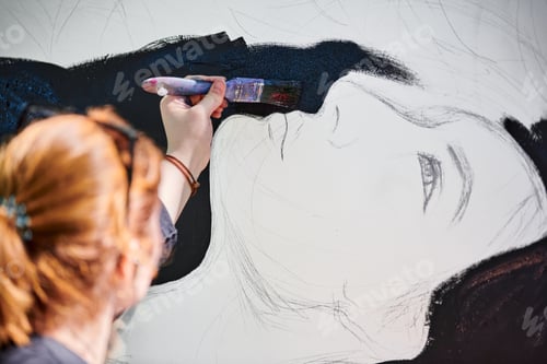 Preview: Woman artist draws with paint brush surreal girl portrait on white canvas at art painting