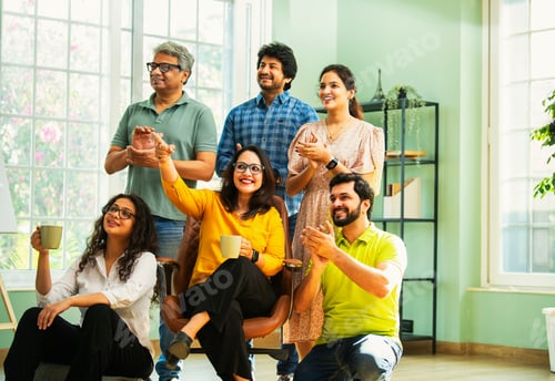 Preview: Young Indian Asian professionals in casuals clapping and looking up, celebrating success together