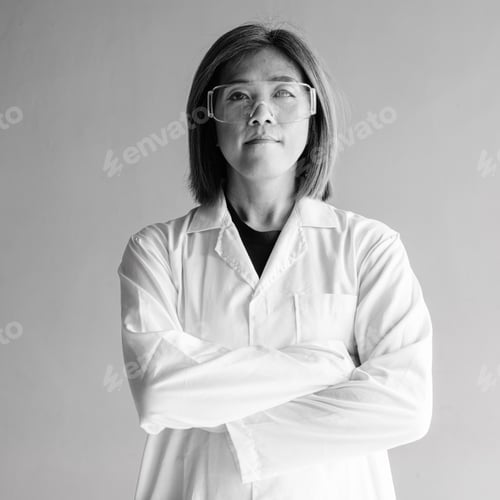 Preview: Confident transgender non-binary person in lab coat and protective glasses