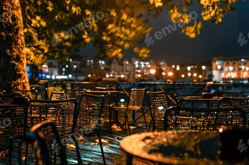 Preview: Empty Outdoor cafe in a rainy evening in city lights. Urban life at autumn