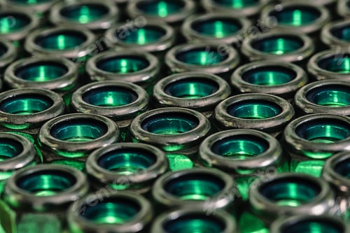 Preview: Closeup shot of endless metal screw nuts with cyan lights coming under it
