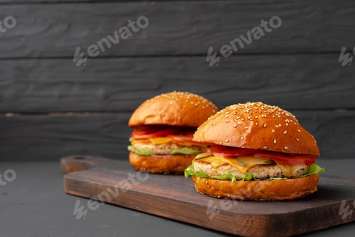 Preview: Close up of fresh tasty burger against black background