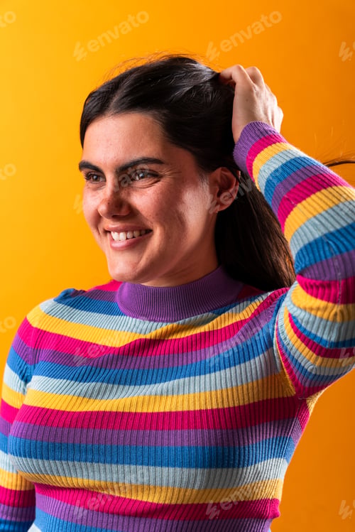 Preview: Young woman smiling and touching her hair on orange background