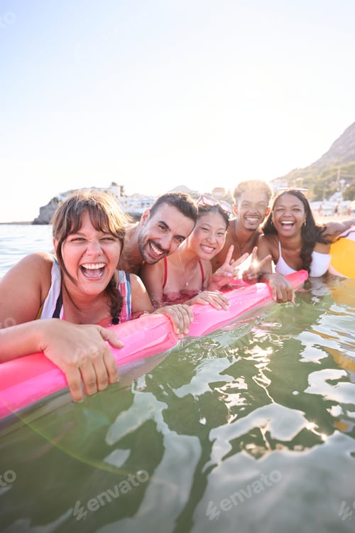 Preview: Portrait of a group of young multiracial happy people having fun floating on a inflatable mattress