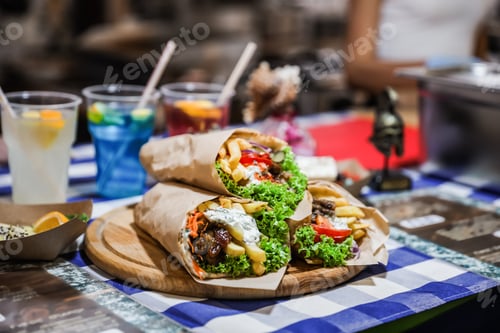 Vista previa: Tasty wraps with french fries on table. Fast food