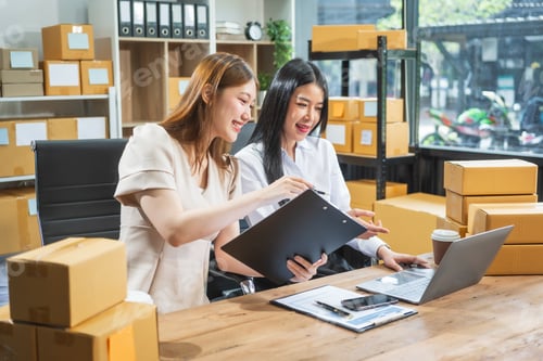 Preview: Two Asian business woman work at desk,selling fashion clothes online.They packing checking items
