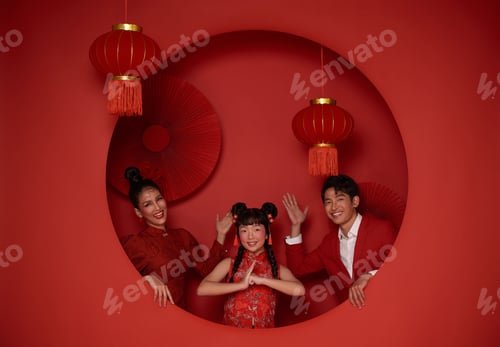 Preview: asian family in red casual attire with gesture of congratulation greeting happy chinese new year