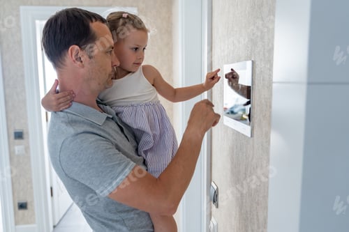 Preview: Daughter in her father using tablet panel application for control smart home living. Wireless device