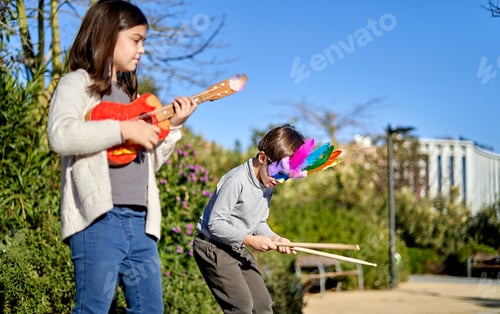 Preview: Children playing with toy instruments in the park