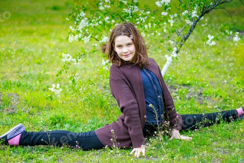 Preview: The child sat on the cross twine. A girl is having fun in a spring park.