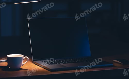 Preview: Workplace in the office with laptop and coffee in the dark room at night.
