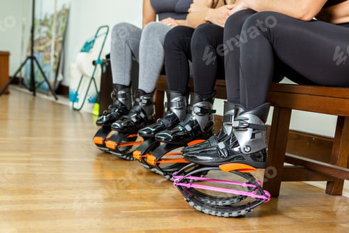 Preview: Sportswomen in jumping shoes sitting on bench in gym