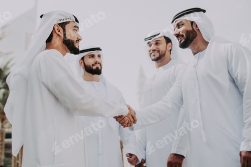 Preview: Group of businessmen talking on the street in Dubai