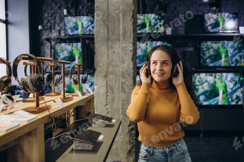 Preview: Woman listening to music in headphones store