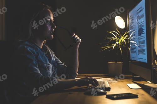 Preview: Young woman working at computer station at home