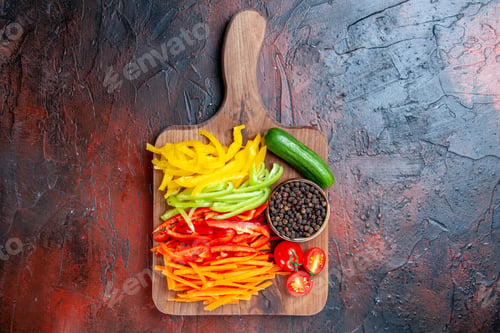Preview: top view colorful cut peppers black pepper tomatoes cucumber on cutting board on dark red table free