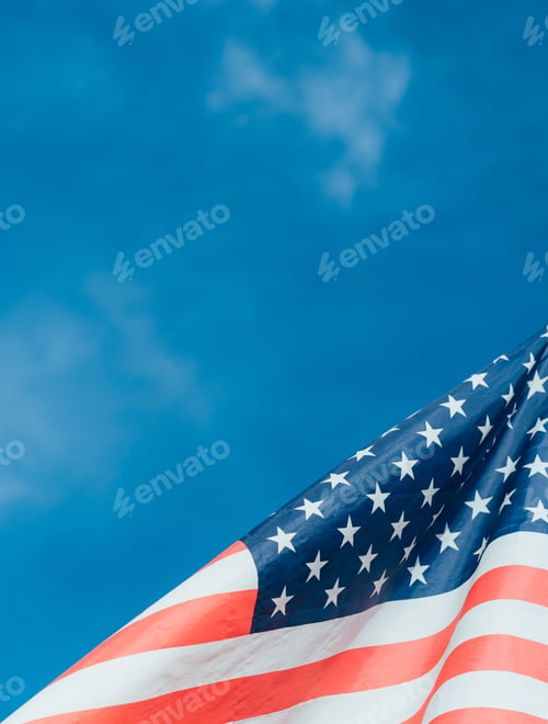 Preview: Closeup of American flag waving in wind against a blue sky