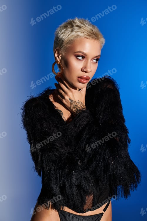 Preview: Stylish woman in black sweater poses confidently against vibrant blue backdrop