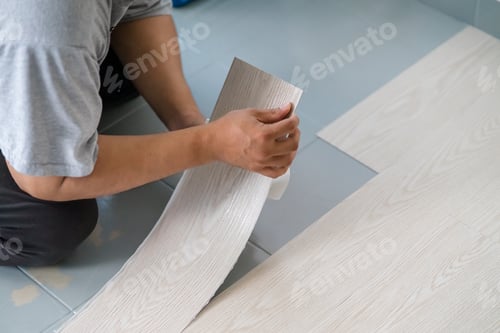 Worker Installing New Wood Grain Vinyl Flooring