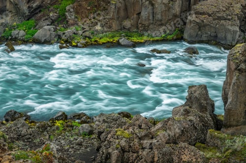 Preview: Vibrant river flowing through rocky terrain.