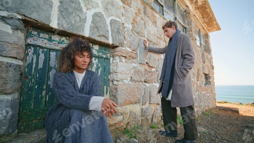Preview: Sad couple posing rocky building. Curly woman blonde man ignoring each other
