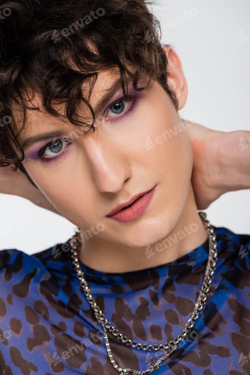 Preview: close up portrait of young queer model with makeup looking at camera isolated on grey