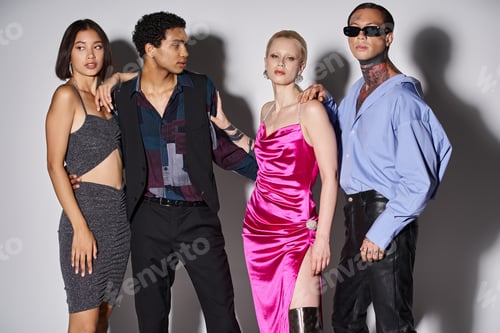 Preview: group of stylish multiethnic friends posing together in festive attire on grey, New Year 2024