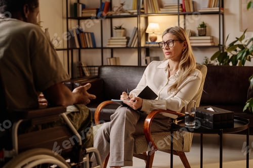 Preview: Female Therapist Listening to Her Patient and Writing in Notebook