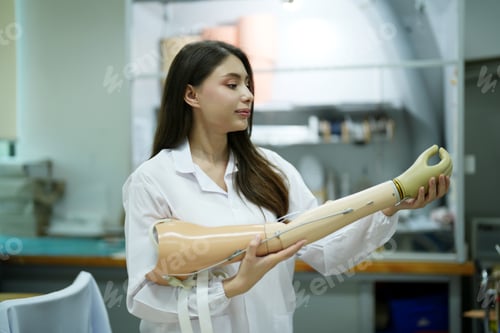 Preview: Orthopedic technician making prosthetic leg for disabilities people in workshop.