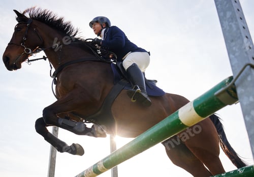 Preview: Head up, heels down. Shot of a young rider jumping over a hurdle on her horse.