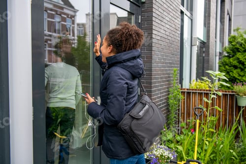 Preview: Curious child peeks into a window on a cloudy day.